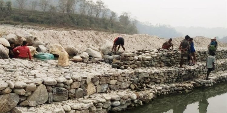 बलान नदीमा अस्थायी तटबन्ध निर्माण गर्दै सुरक्षाकर्मी