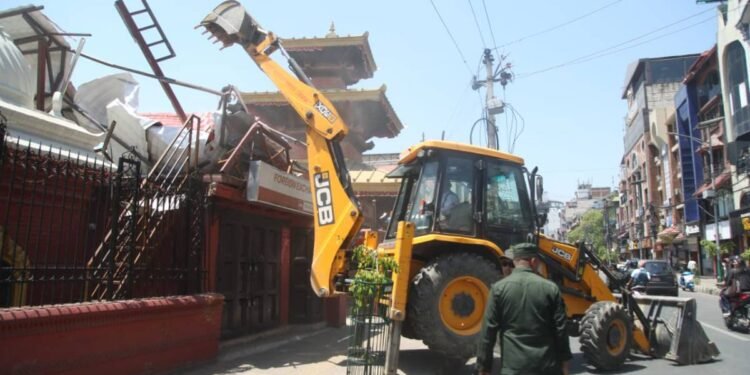 काठमाडाैं महानगरले चलायाे त्रिदेवी मन्दिर ठमेलमा बनेको अनाधिकृत संरचनामा डाेजर